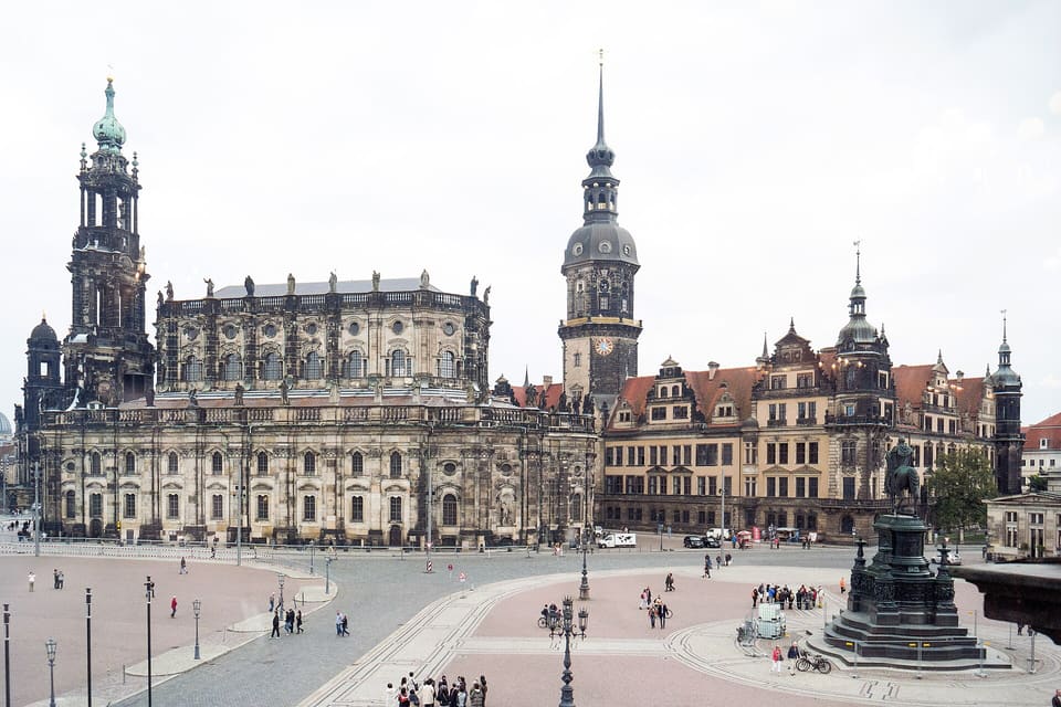 The Theaterplatz seen from above, with the Hofkirche and its tower at the left, the Hausmannsturm and the Residenzschloss at the right, and a bronze equestrian monument in the square.